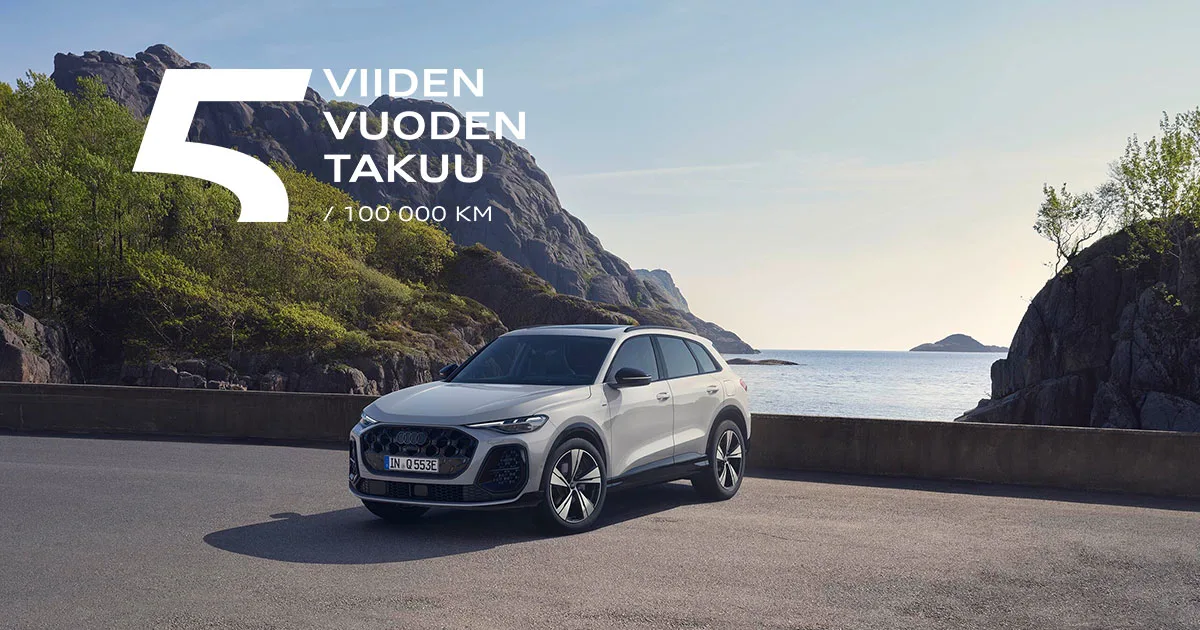Audi Q5 aurinkoisella parkkipaikalla veden äärellä.