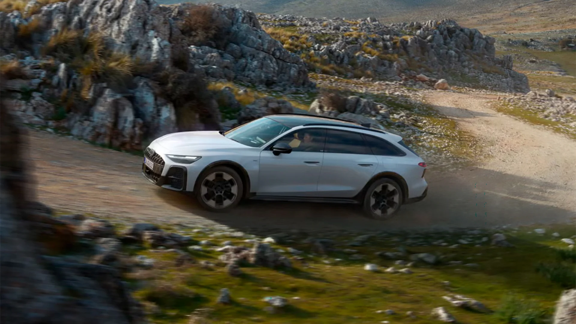 Audi A6 allroad ajaa mutkaista hiekkatietä.