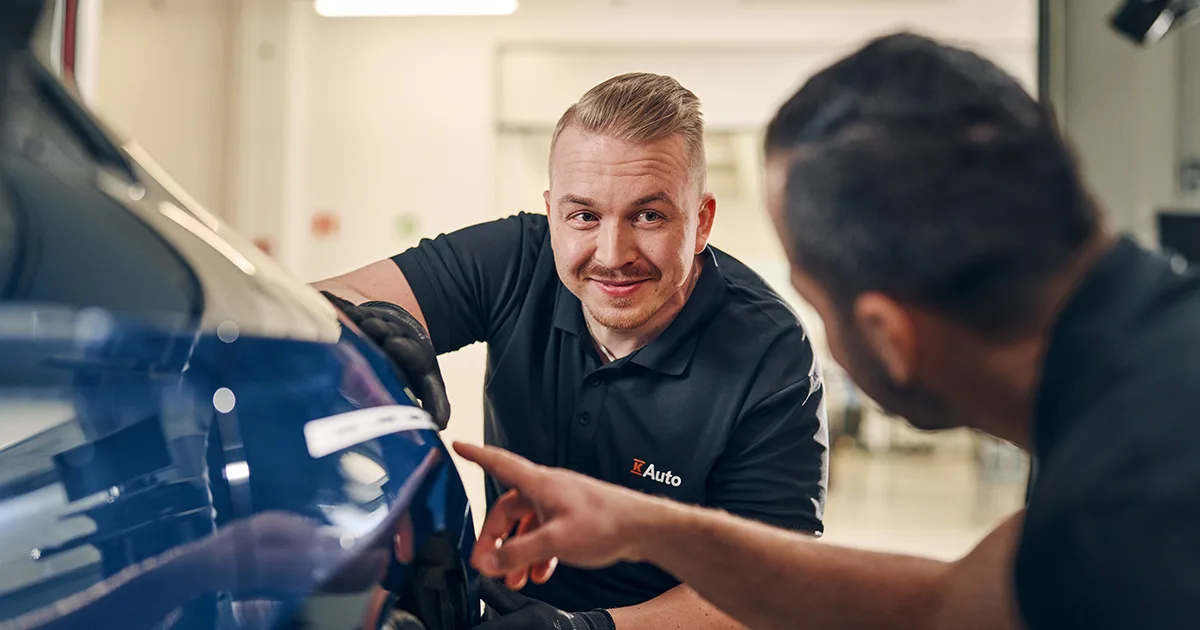 Kaksi K-Auton mekaanikkoa tarkistaa autoa.