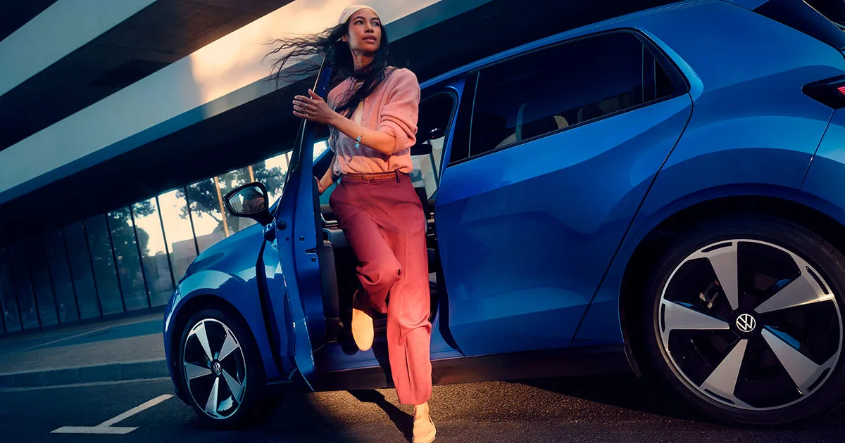 Nainen astuu ulos sinisestä Volkswagen ID. Polosta.