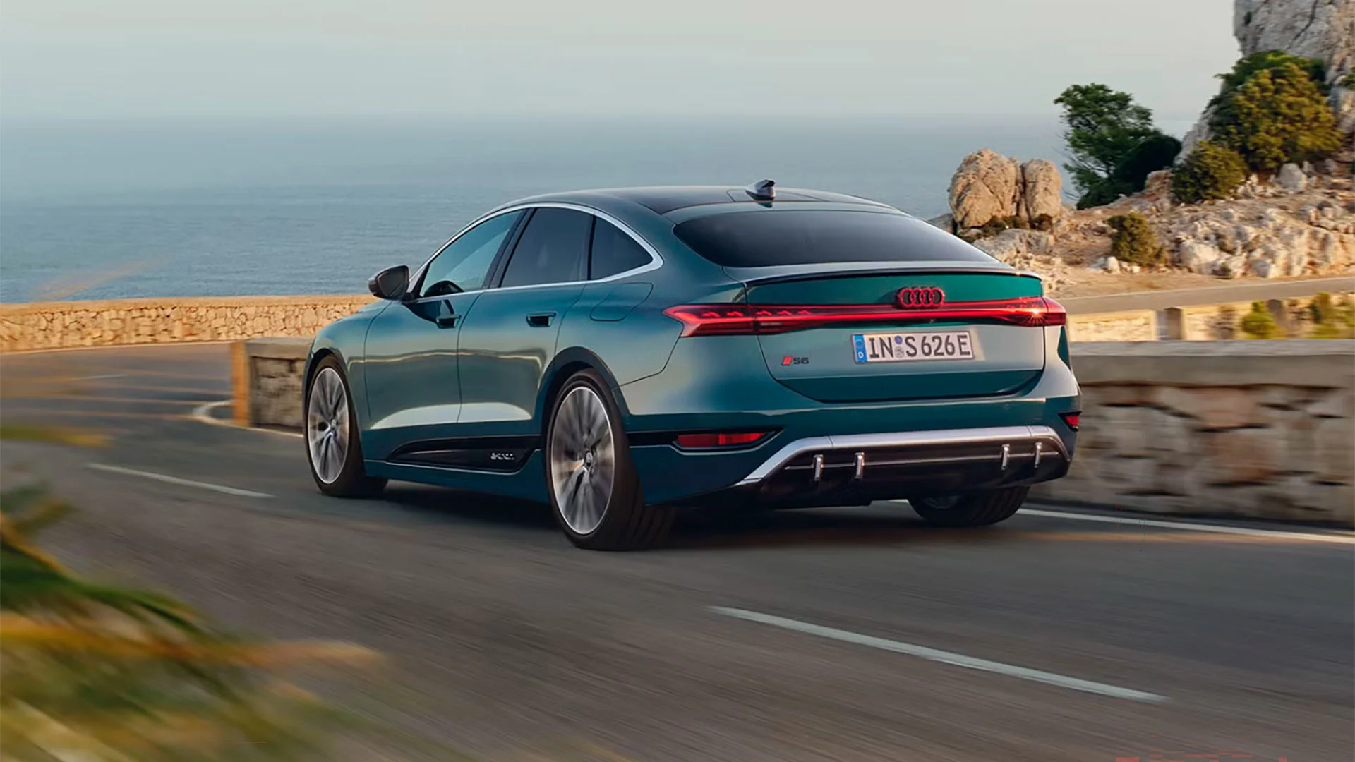 Turkoosi Audi S6 e-tron Sportback maantieajossa.