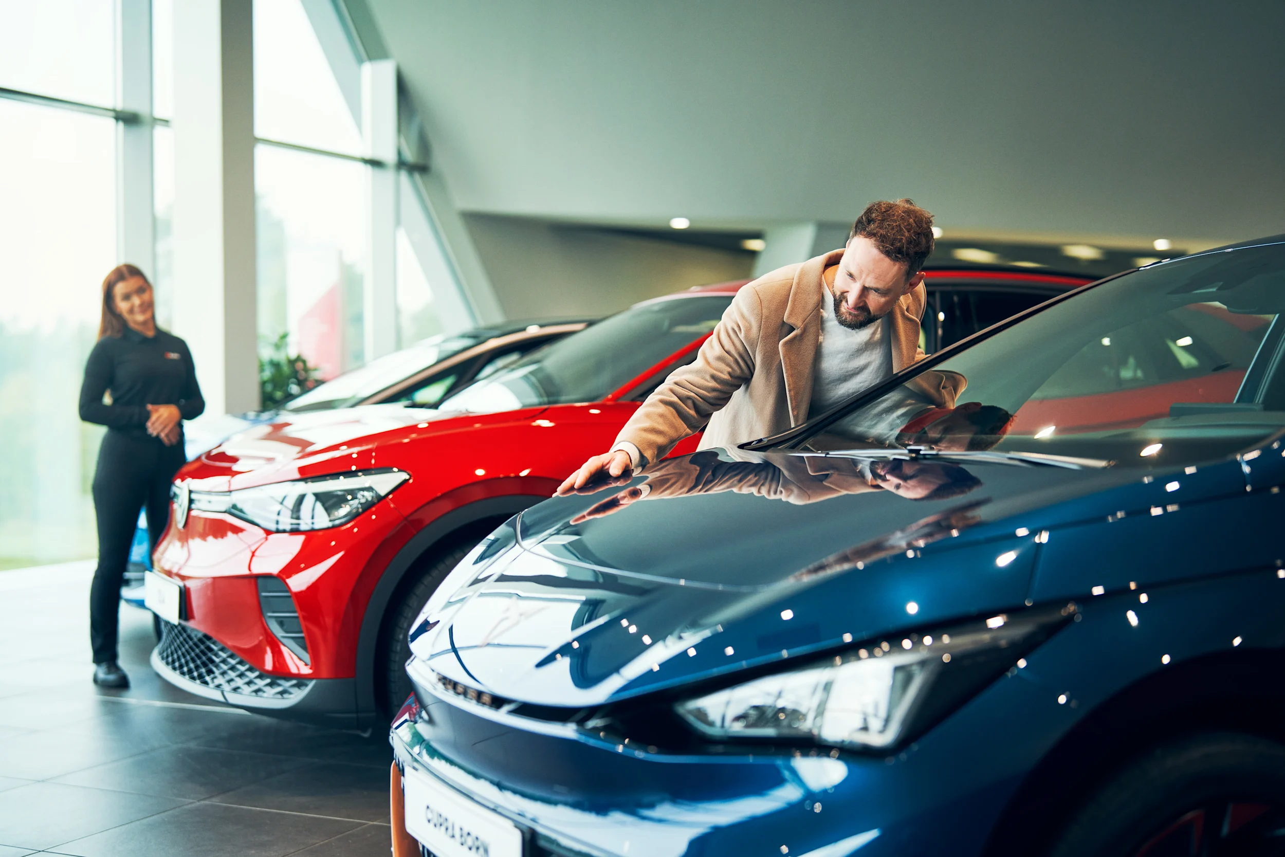 Myyjä auttaa asiakasta valitsemaan leasingautoa.