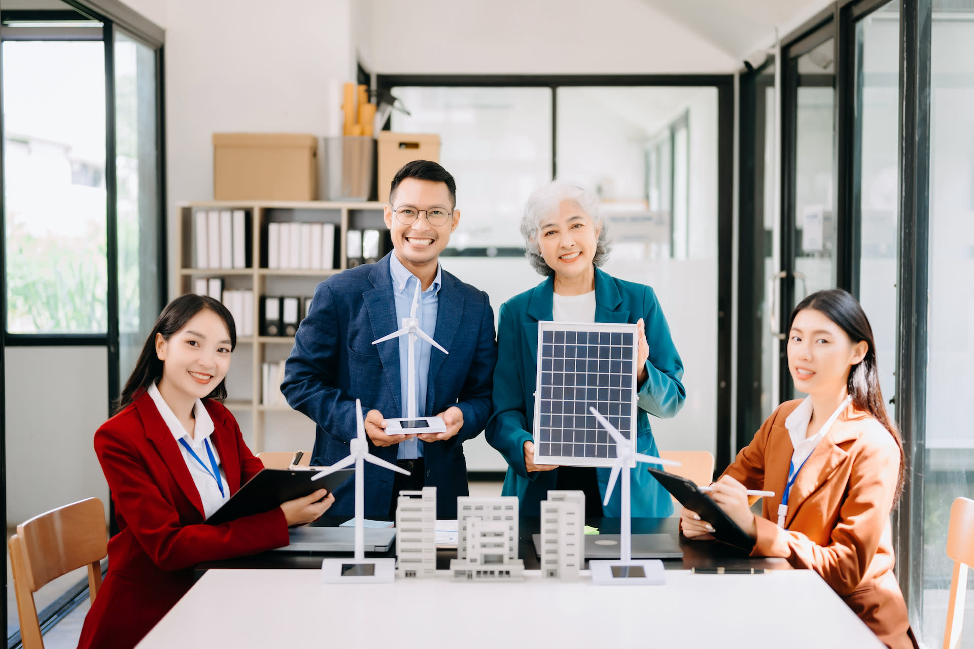 1 man and 3 women in an office showing a renewable energies project