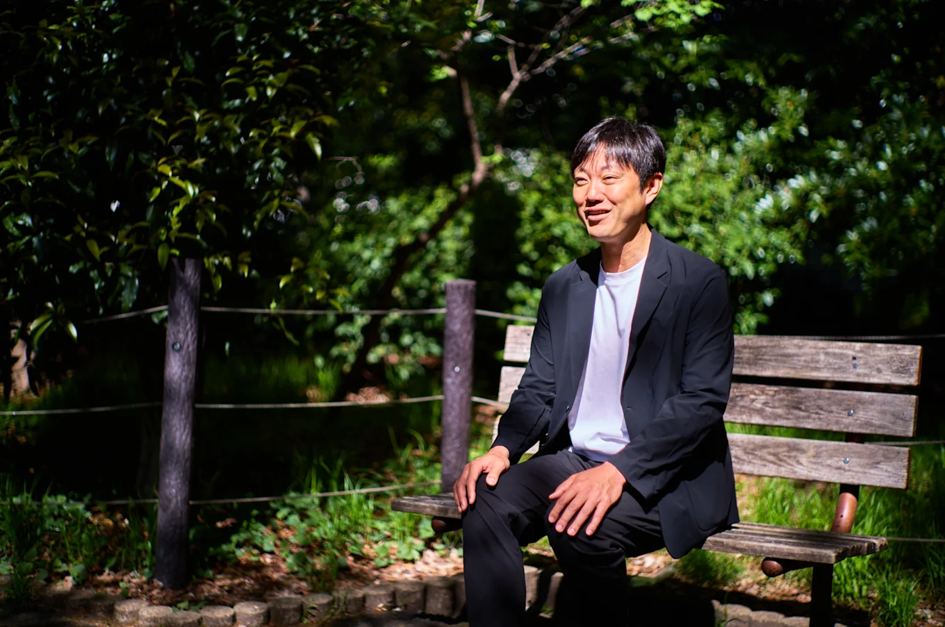 石川善樹さんのインタビューポートレート（屋外のベンチにて）