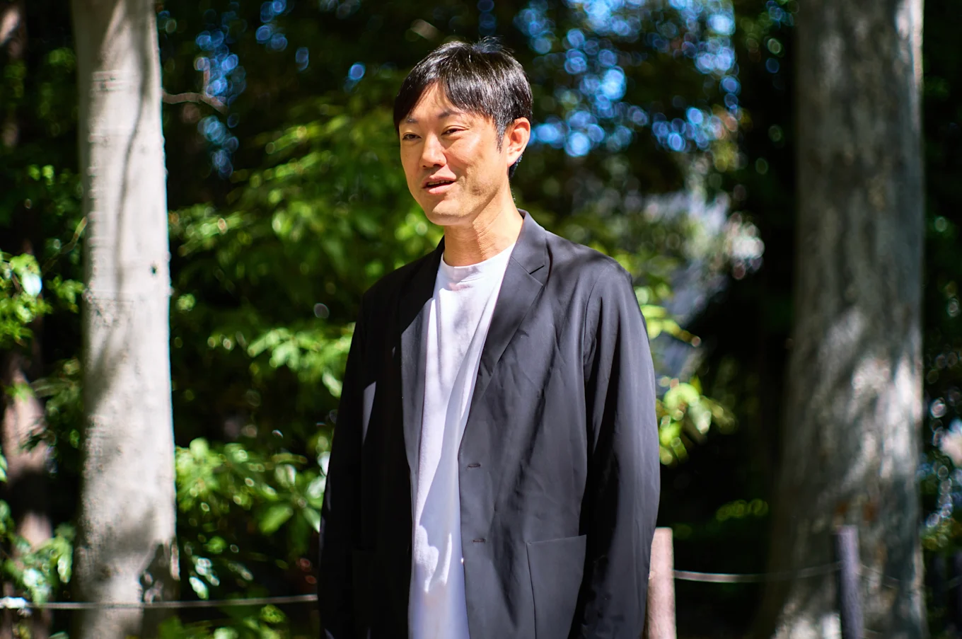 石川善樹さんのインタビューポートレート（屋外のベンチにて）