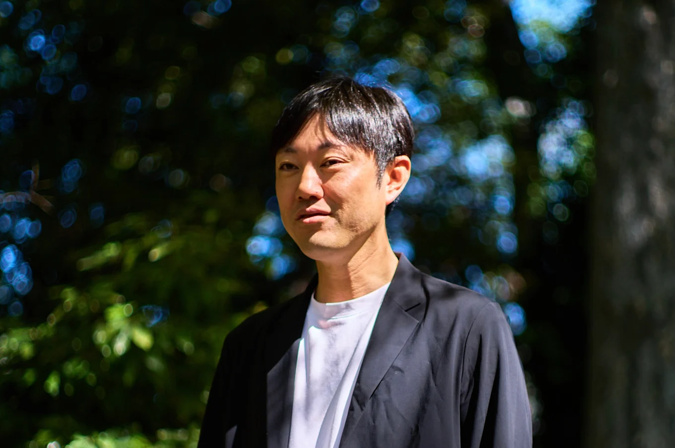 石川善樹さんのインタビューポートレート（屋外のベンチにて）
