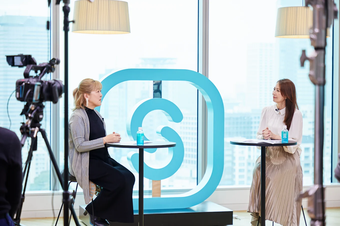 SmartHRのロゴを背景に対談中の笹原さんと堀井さん