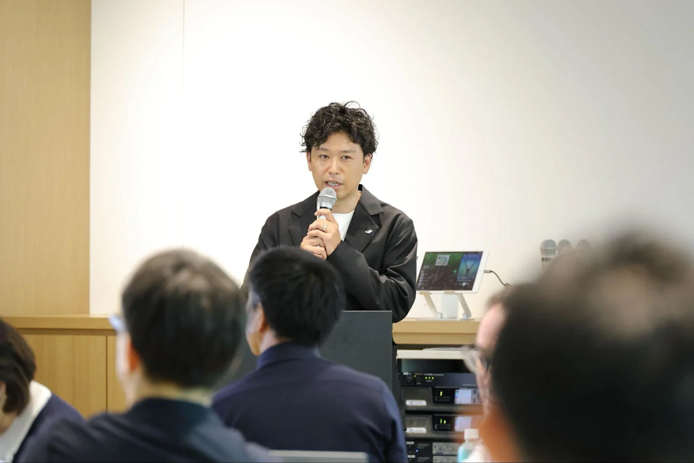 人々の前でマイクを持って話す須藤さん