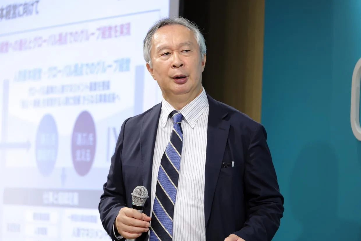 マイクをもって真剣な表情で話す有沢さん