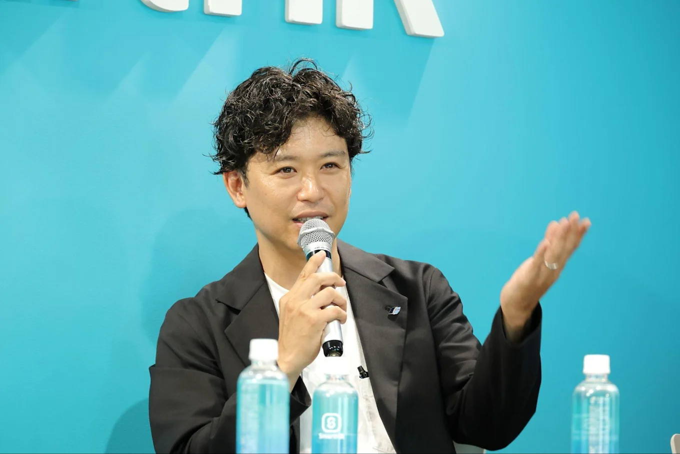 マイクを持って話す須藤さん
