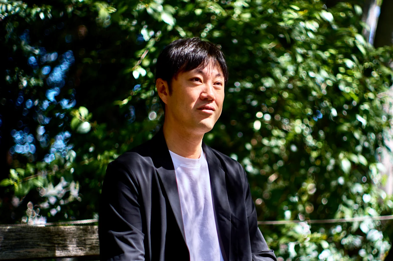 石川善樹さんのインタビューポートレート（屋外のベンチにて）