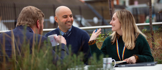 Three people sitting around table and speaking