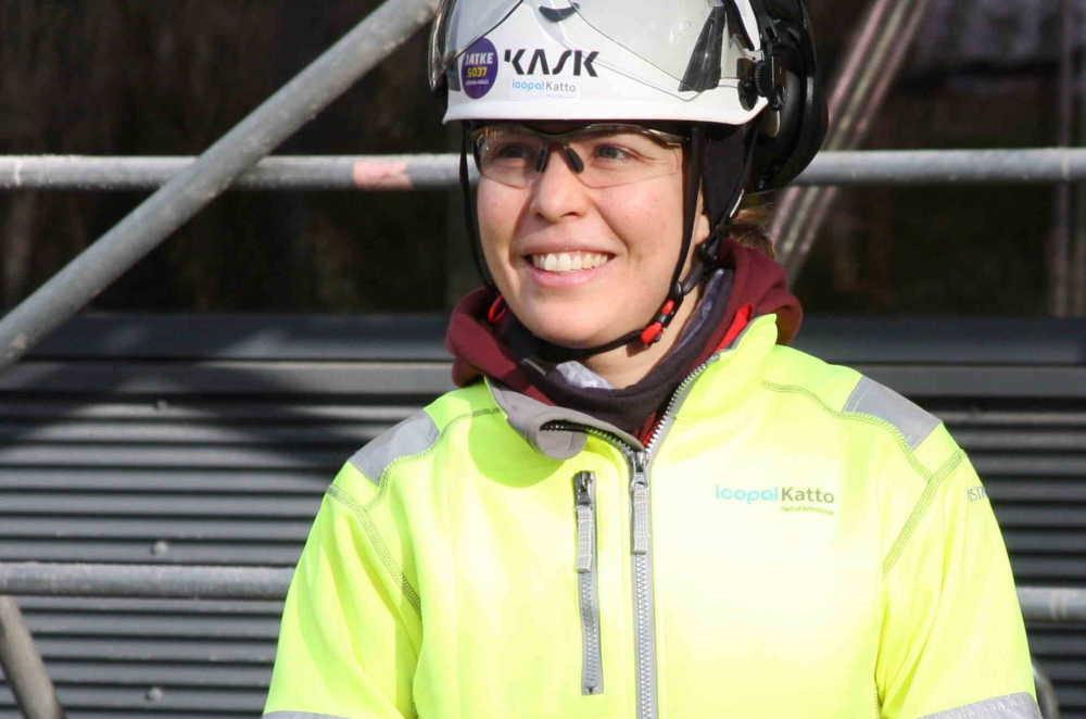 Työturvallisuusinsinööri Marianne Näsänen Icopal Katto Oystä kypärä päässä ja huomiovärinen takki yllään