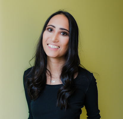Juno college student with long black hair smiling at the camera