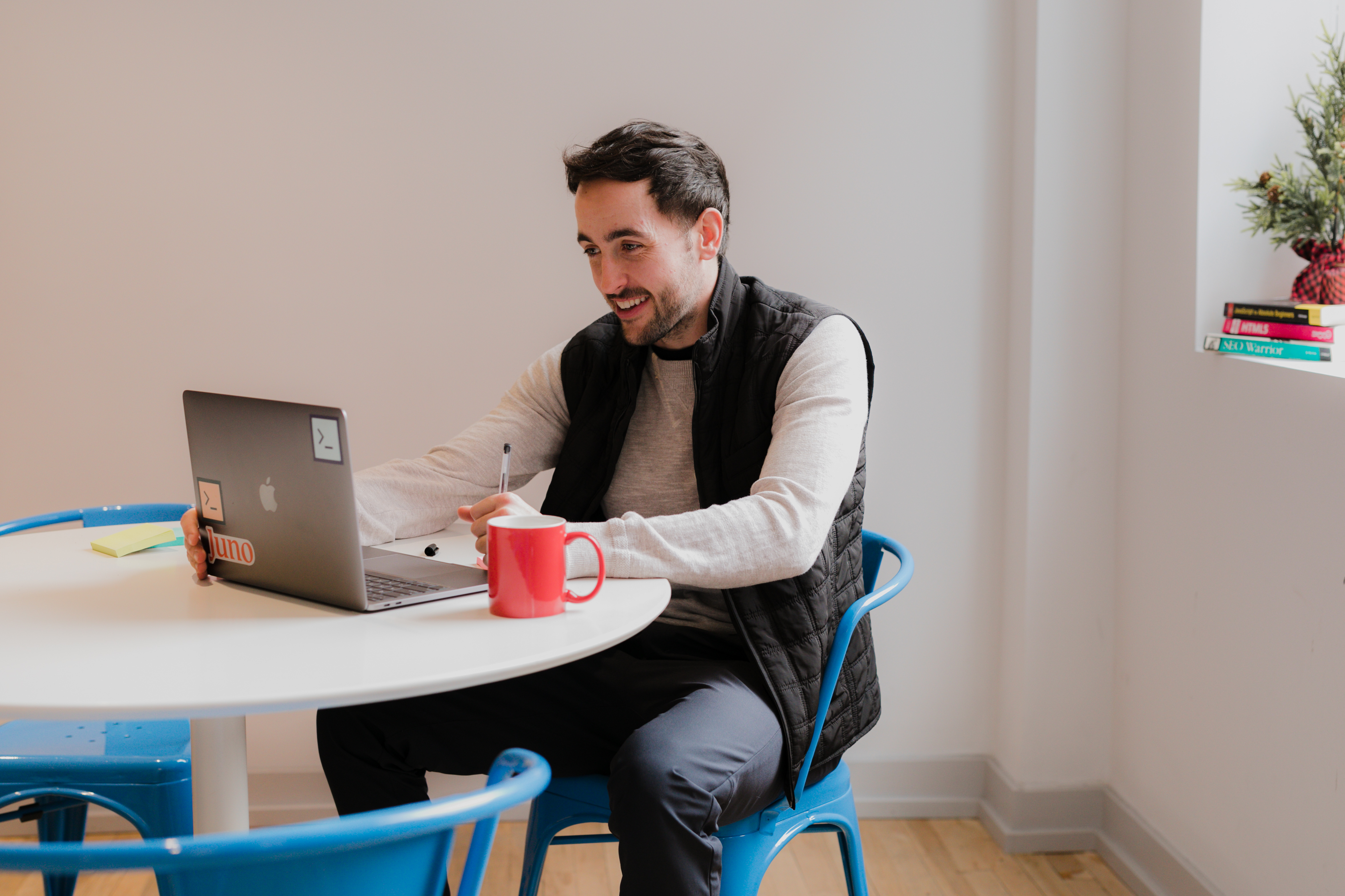 Danny working on a laptop with pen and mug