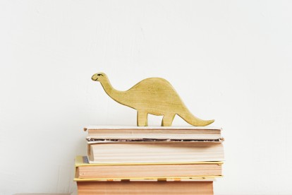 Smiling brachiosaurus toy on a stack of books