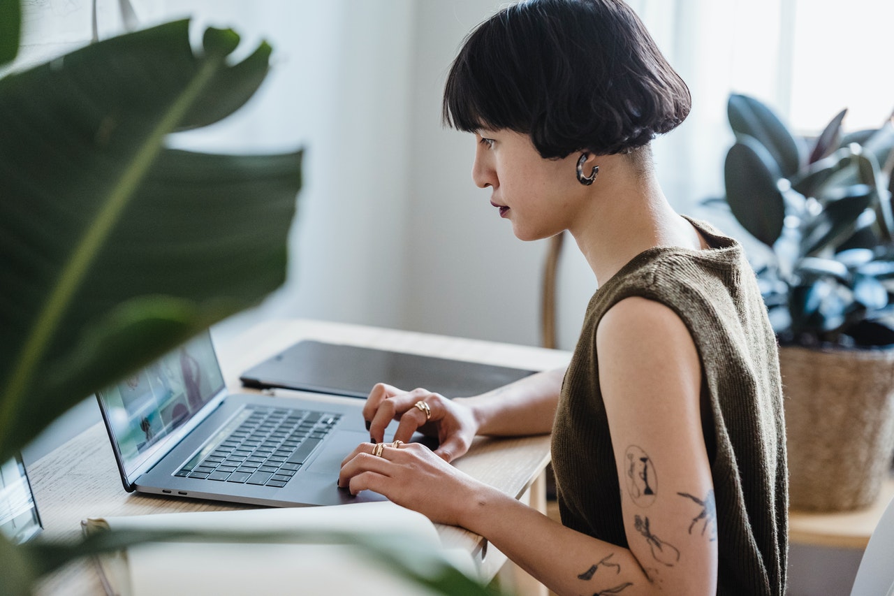 Creative woman typing on a laptop at home at Juno College's Live Online course