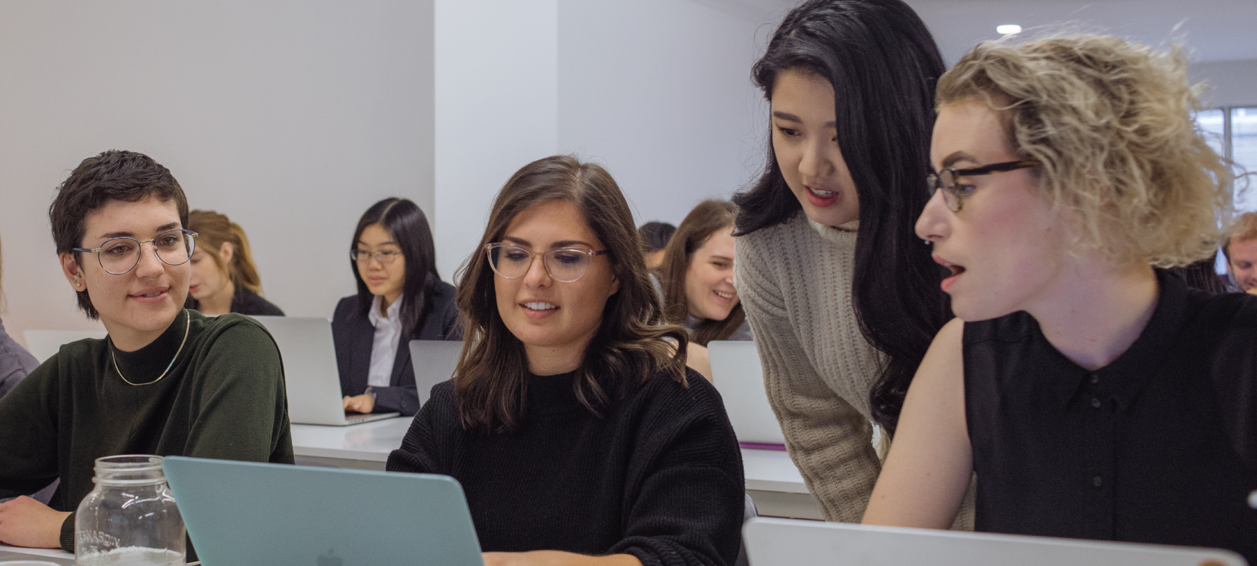An instructor helps students in a classroom at Juno College's Web Development course in Toronto.