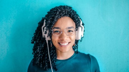 Person wearing headphones and smiling at the camera
