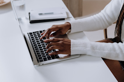 Hands typing on a laptop