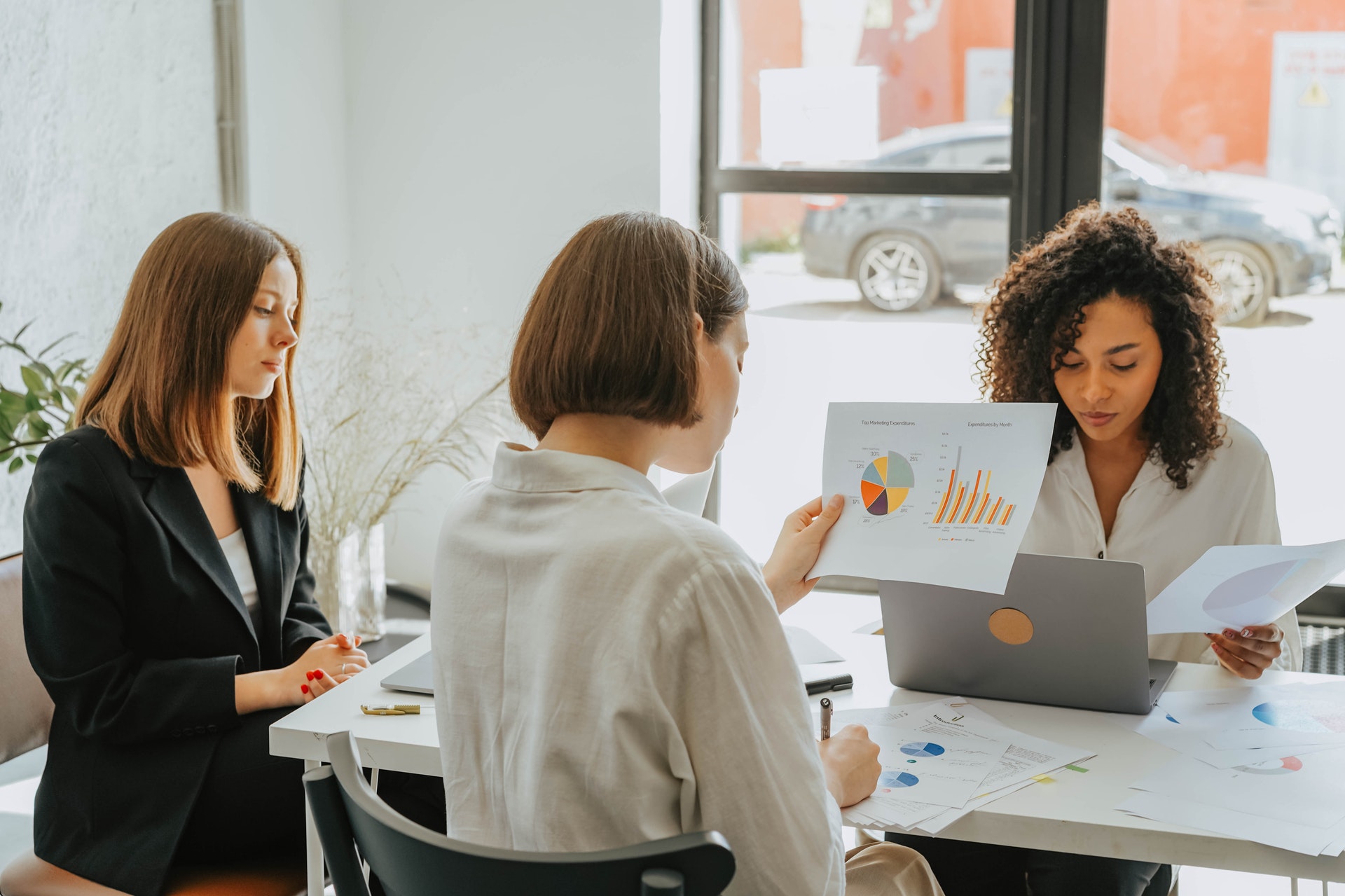 A group of women working with data analytics charts and graphs
