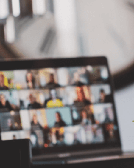 Blurred image of a zoom call on laptop.