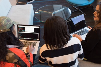 Three women coding on their laptops at Juno College