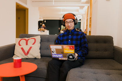 Man sitting on couch and staring at computer with headphones on