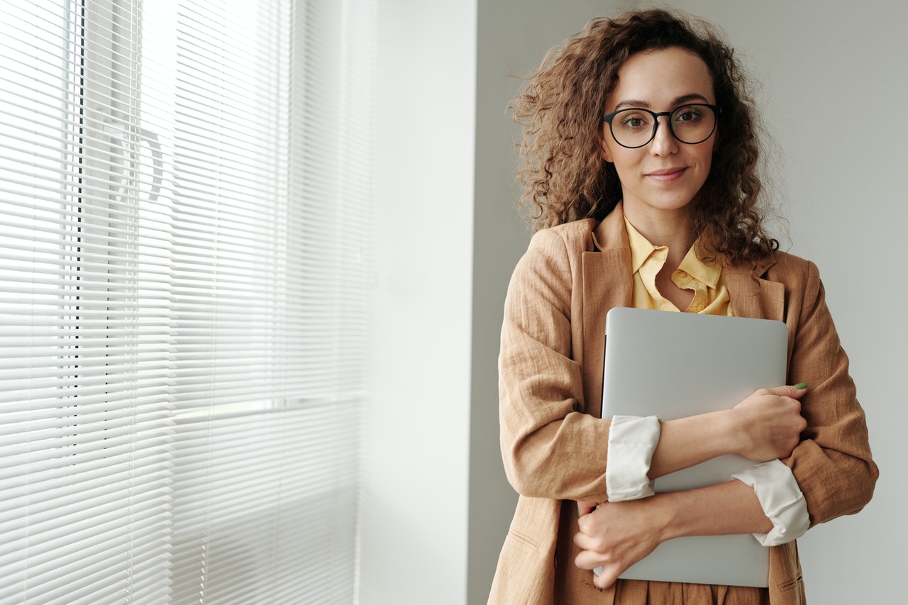 A professional woman holding her laptop