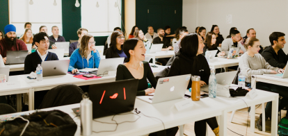 Students in a classroom laughing during one of Juno's in-person classes.