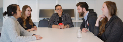 HackerYou staff sitting around a table laughing