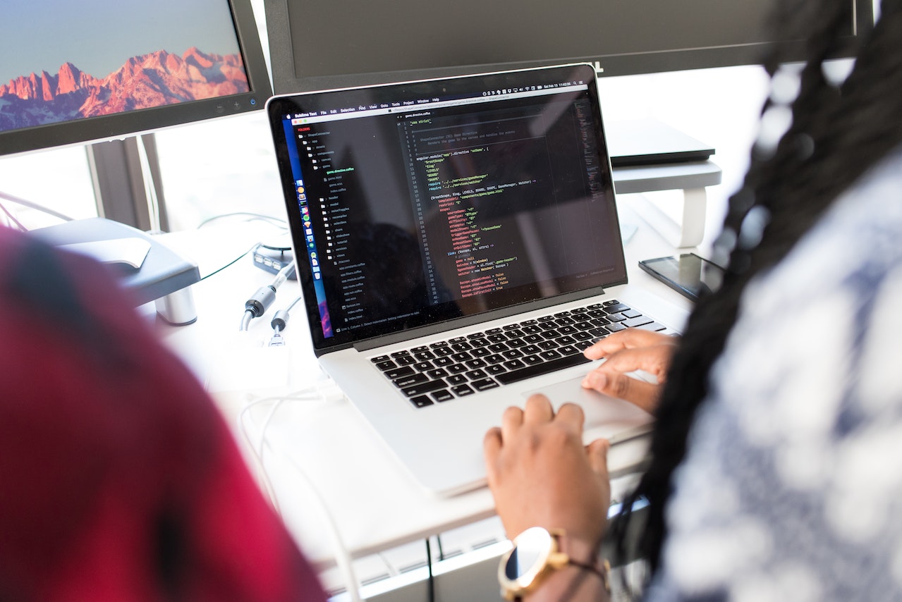 Hands typing/coding on a laptop