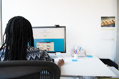Back of woman sitting at computer desk