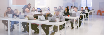 Students sitting in a classroom at HackerYou looking at their computers