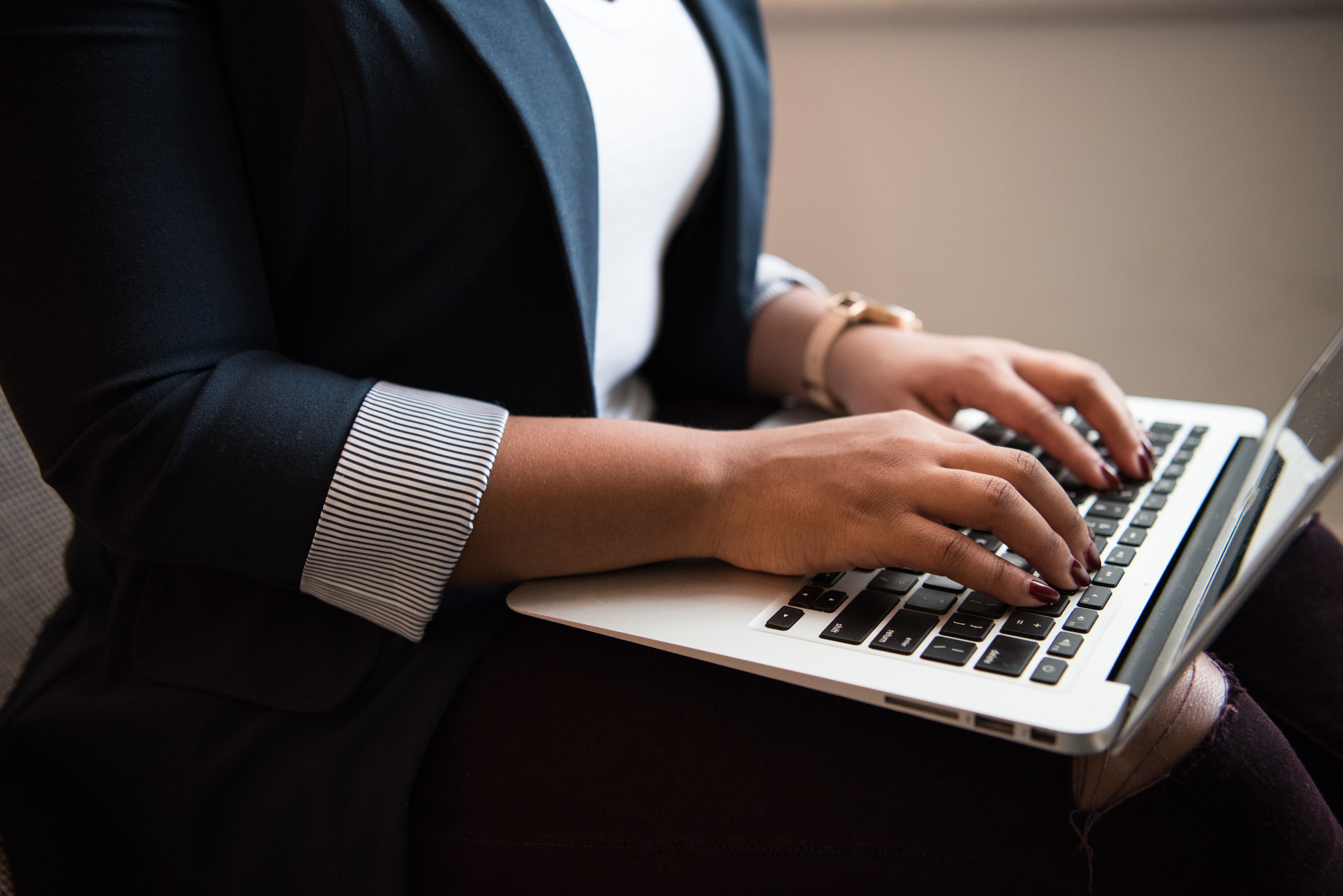 Person in business clothes typing on laptop
