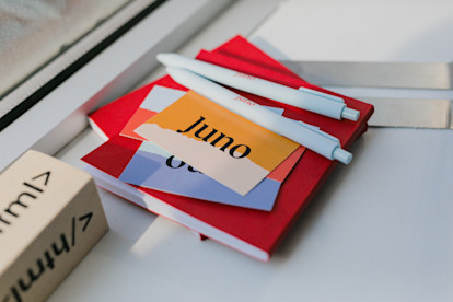 Juno business cards and pens on a red notebook