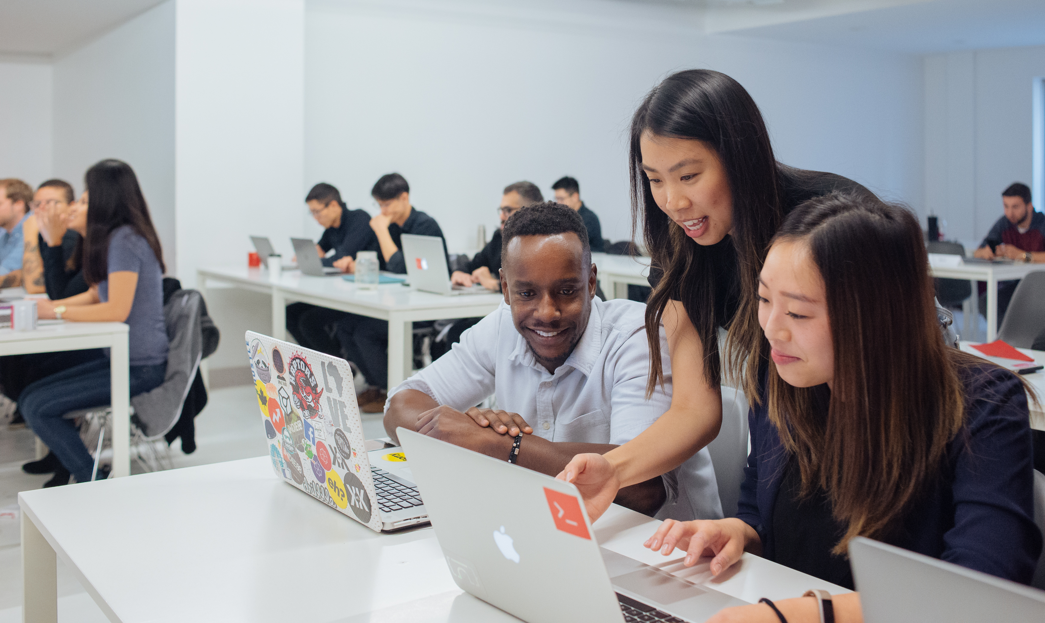 Instructor Jenny Ngo working with two Web Development bootcamp students.