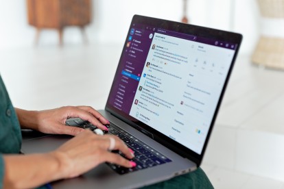 Person typing on laptop with Slack