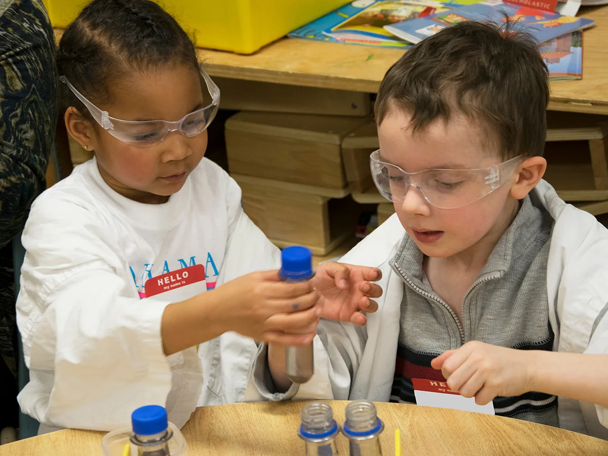 Deux participants de Scientifiques à l’école examinent des éprouvettes dans leur classe