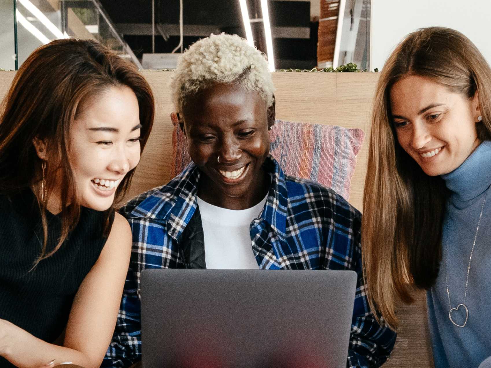 Three women having fun in-front of a laptop