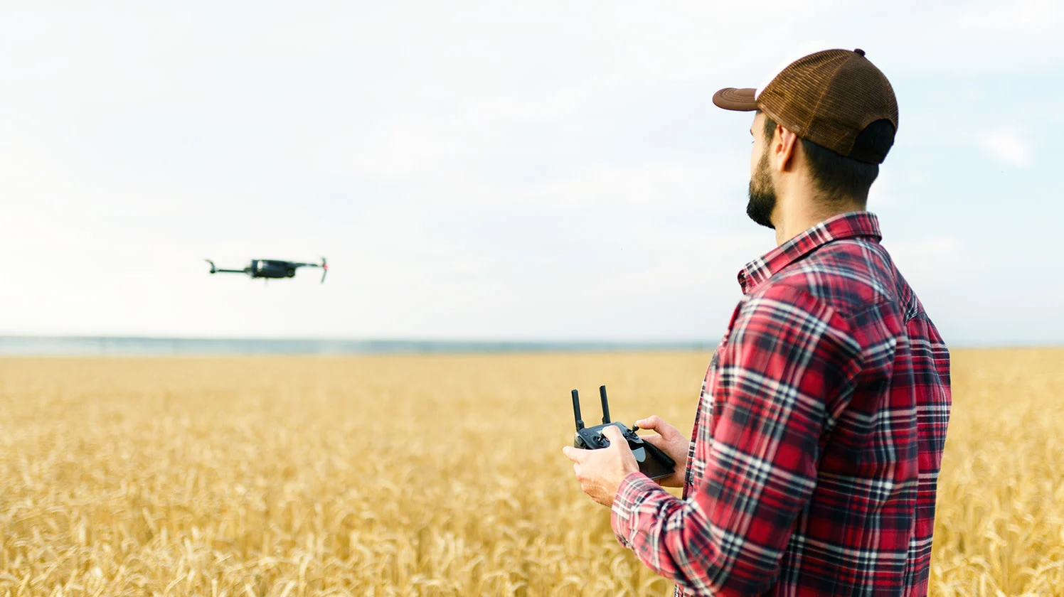 A farmer flying a drone over his field
