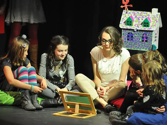 A Fondation Deuil-Jeunesse employee surrounded by a group of seated children