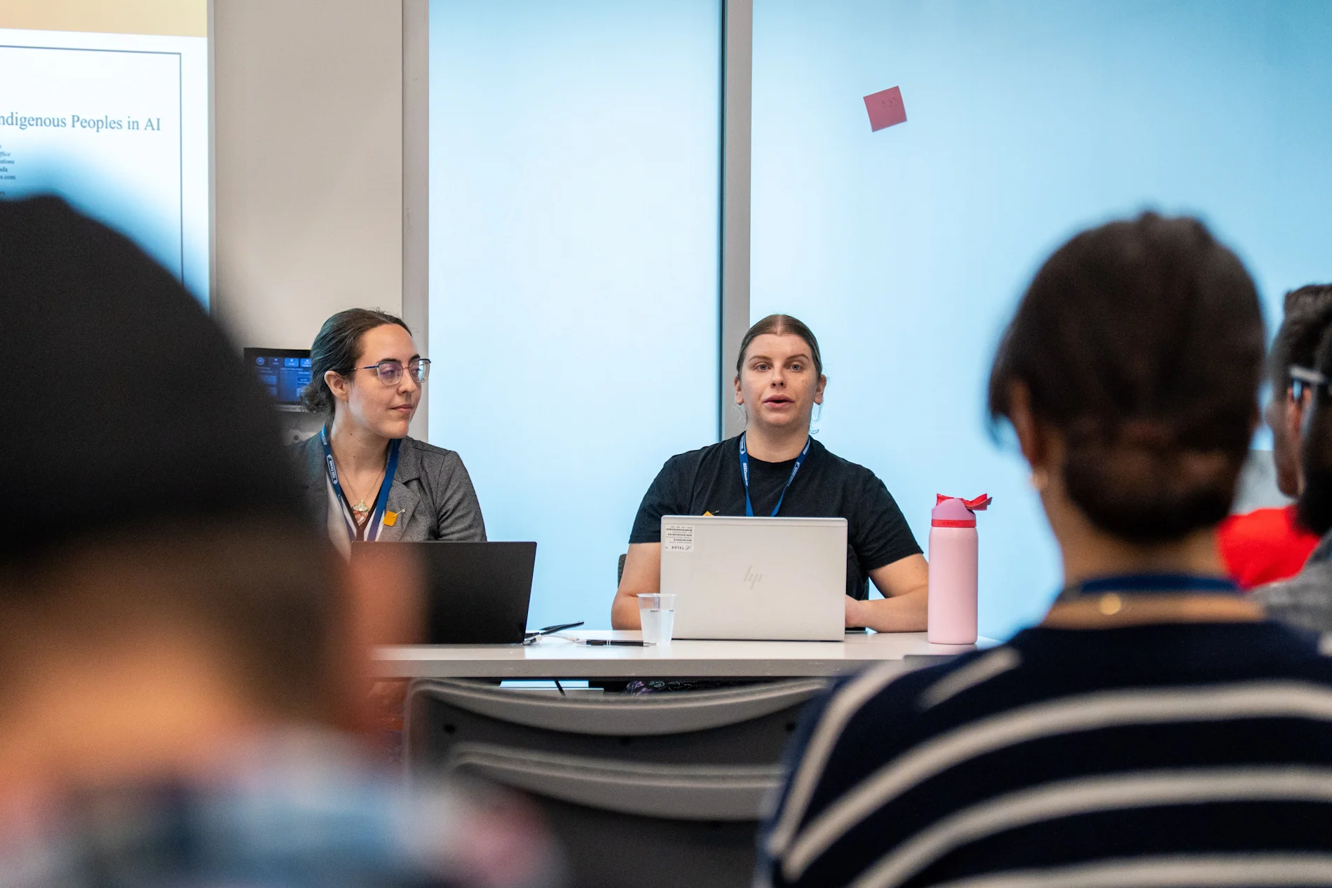 Kendal Burtch and Melanie Demers speaking at a desk.
