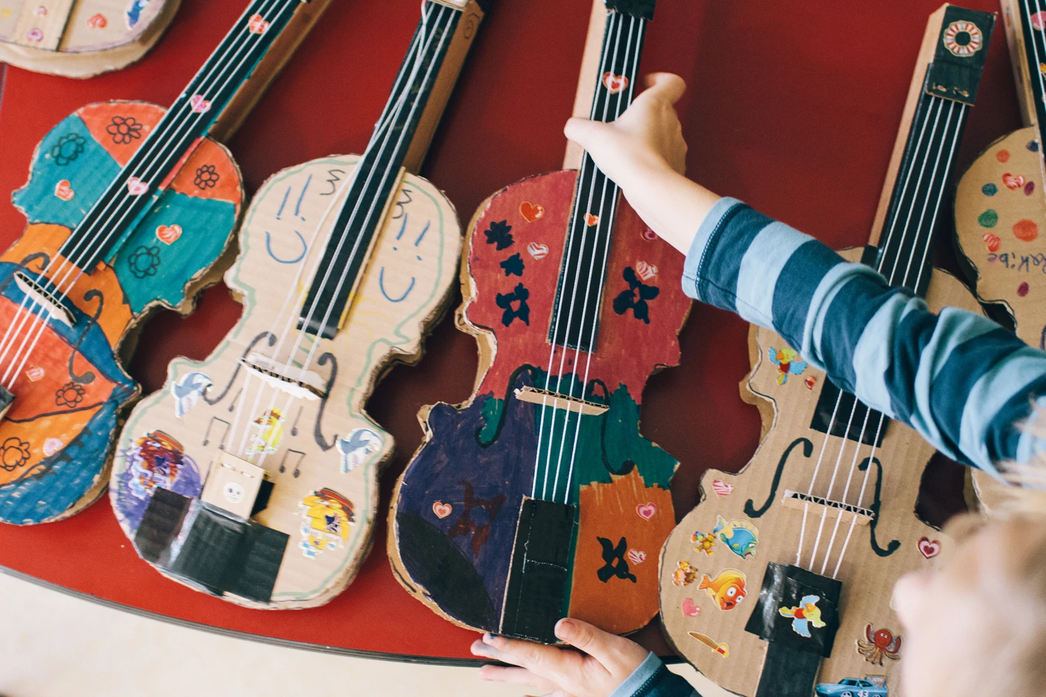 Four cardboard guitars decorated by the students enrolled in the YONA-Sistema after-school program.