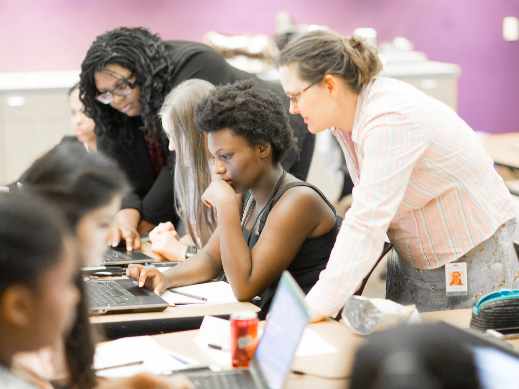Female students working on a laptop with their instructors