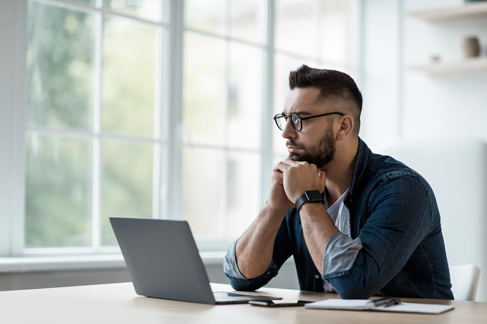 Man sits in front of open laptop 