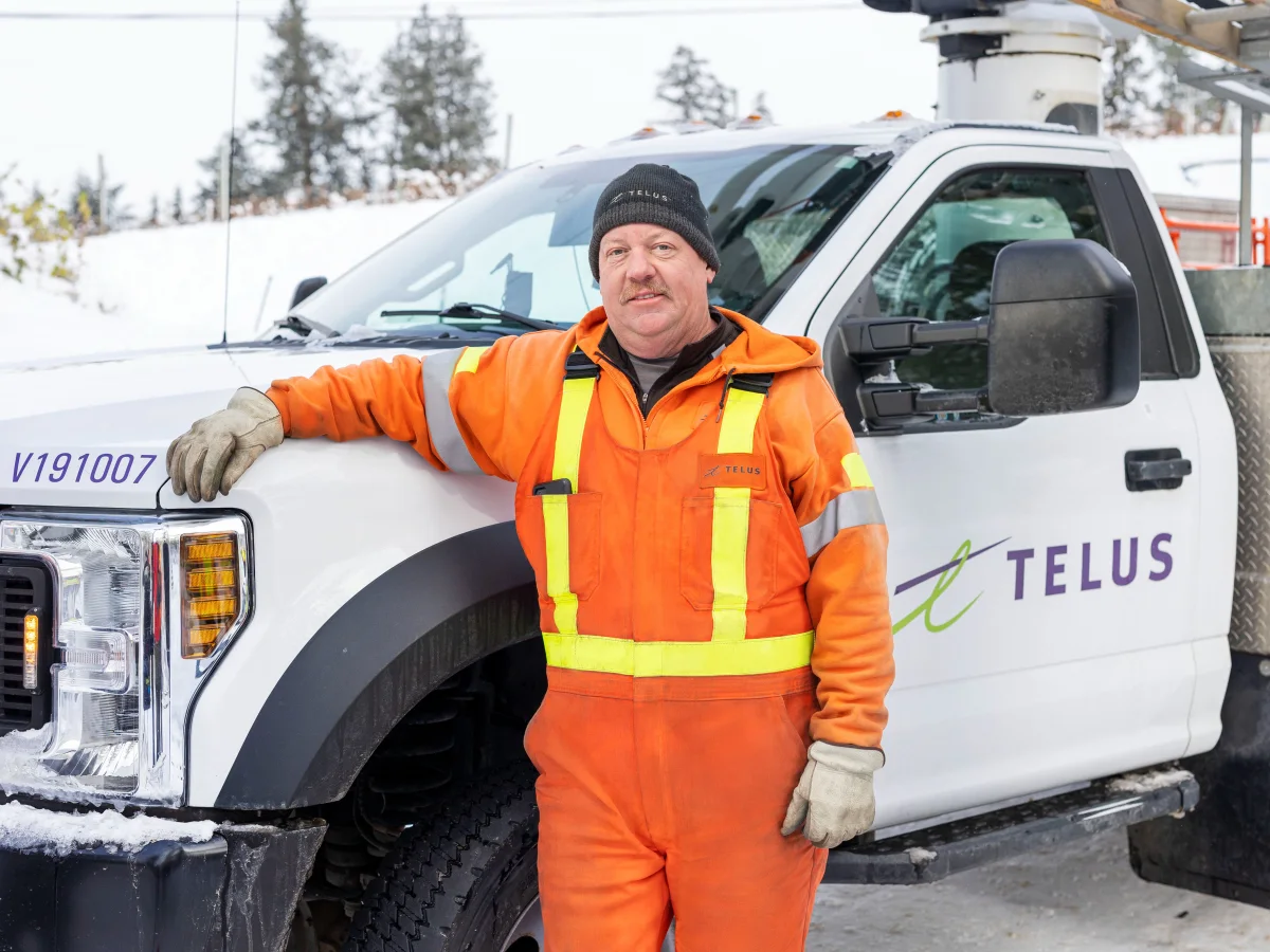 Technicien TELUS à côté d’un camion.