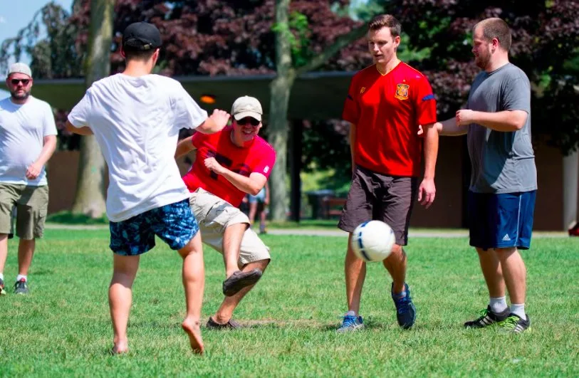 TELUS Digital team members play soccer outdoors