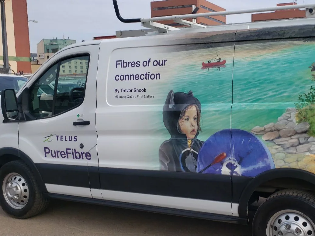 Side view of a TELUS fleet vehicle wrapped with artwork by local Indigenous artist, Trevor Snook.