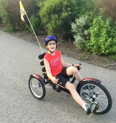 Jon pédalant dans le quartier sur son vélo horizontal modifié